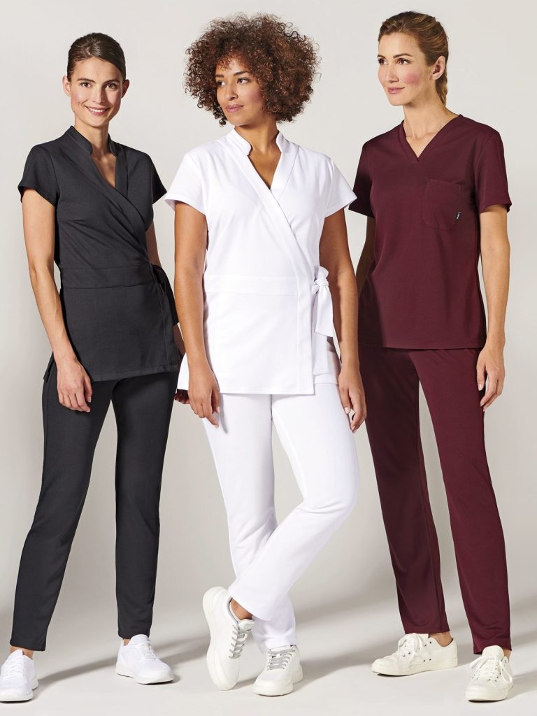 Trois femmes portant des uniformes médicaux de différentes couleurs.